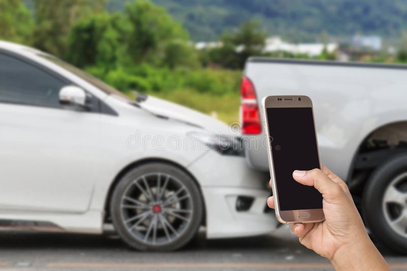 Ręka kobiety mienia smartphone i bierze fotografię wypadek samochodowy obraz stock Ręka kobiety mienia smartphone i bierze fotografię wypadek samochodowy obraz stock