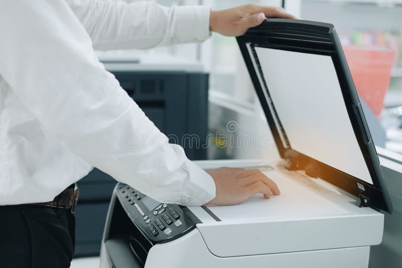 Ręka stawia dokumentu papier w drukarka przeszukiwacz lub laser odbitkową maszynę w biurze