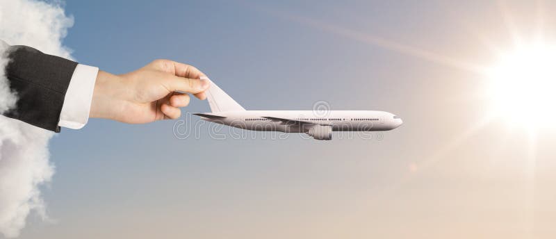 Hand holding white airplane in blue sky. Hand holding white airplane in blue sky