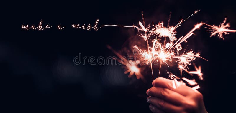 Ręki mienia Sparkler płonący wybuch z robi życzenia słowu na b fotografia stock Ręki mienia Sparkler płonący wybuch z robi życzenia słowu na b fotografia stock