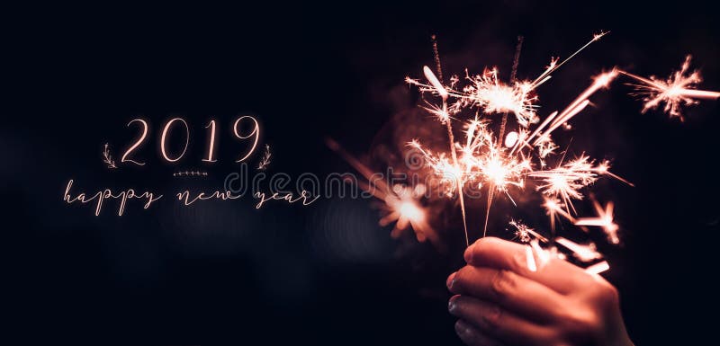 Ręki mienia Sparkler płonący wybuch z szczęśliwym nowym rokiem 2019 dalej fotografia royalty free