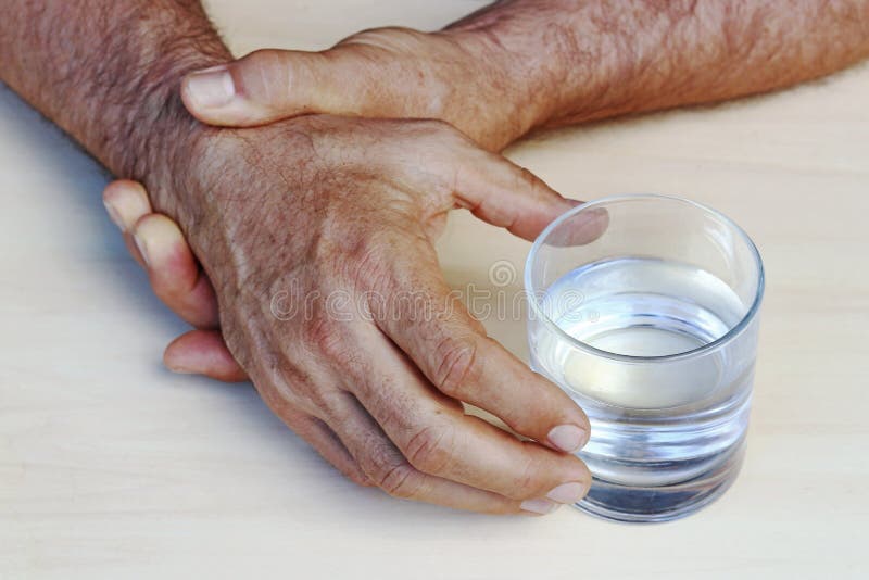 Ręki mężczyzna z Parkinson ` s chorobą drżą