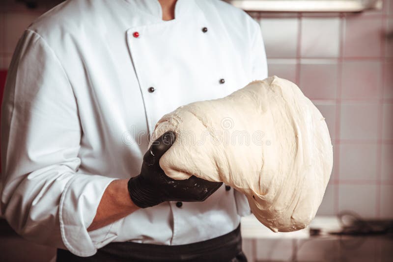 Ręki piekarz ugniatają warstwę ciasto na kuchni obrazy stock Ręki piekarz ugniatają warstwę ciasto na kuchni obrazy stock