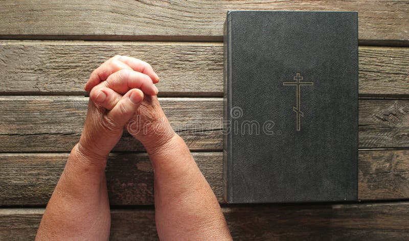 Ręki starsza kobieta one modlą się blisko Świętej biblii książki na starych nieociosanych deskach Religii pojęcie, odgórny widok obraz stock Ręki starsza kobieta one modlą się blisko Świętej biblii książki na starych nieociosanych deskach Religii pojęcie, odgórny widok obraz stock
