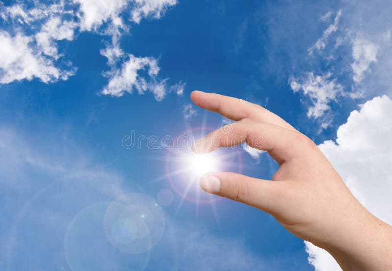 Hand holding the sun in blue sky. Hand holding the sun in blue sky