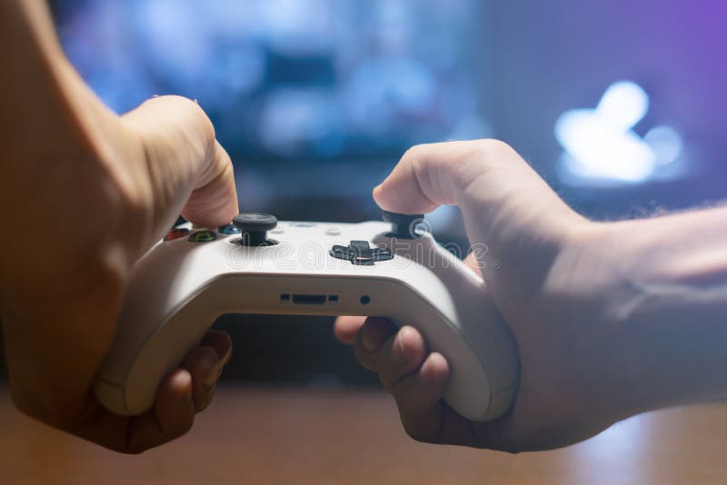 Ręki trzyma joystick i sztuk gra wideo w nocy f w domu zdjęcie royalty free Ręki trzyma joystick i sztuk gra wideo w nocy f w domu zdjęcie royalty free