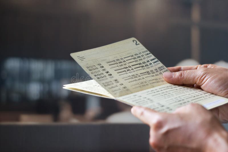 Ręki trzyma oszczędzania obrachunkowego passbook, książkowy bank na banka biurze fotografia stock Ręki trzyma oszczędzania obrachunkowego passbook, książkowy bank na banka biurze fotografia stock