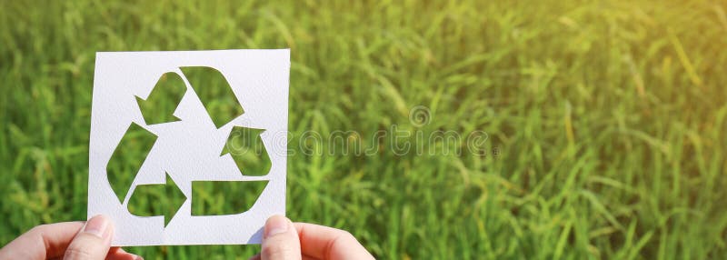 Rżnięty papier z logem przetwarzać nad zieloną trawą