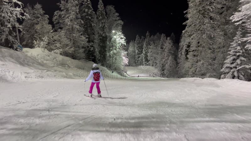 's avonds skiën op een verlichte helling met sneeuwbedekte bomen met vorst in een sprookje