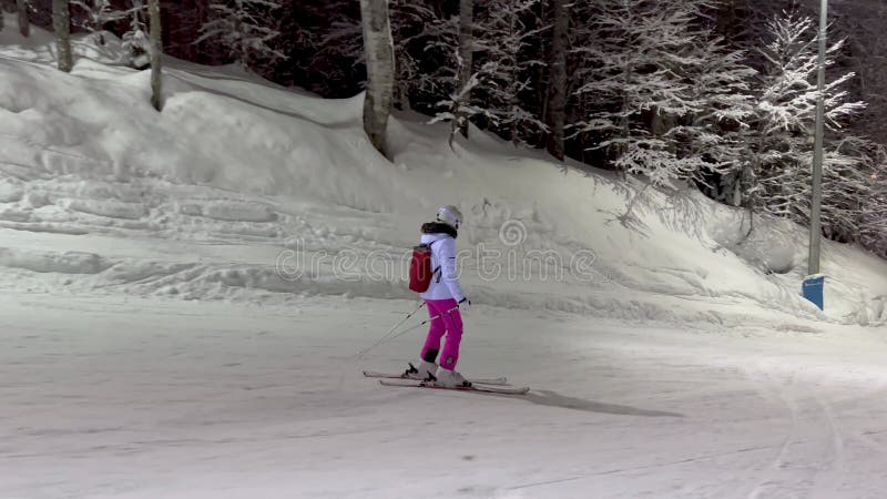 's avonds skiën op een verlichte helling met sneeuwbedekte bomen met vorst in een sprookje