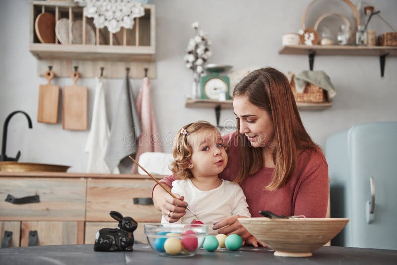 It`s cameraman there. Mother teaches daughter to paint the eggs for the Easter holidays royalty free stock image It`s cameraman there. Mother teaches daughter to paint the eggs for the Easter holidays royalty free stock image