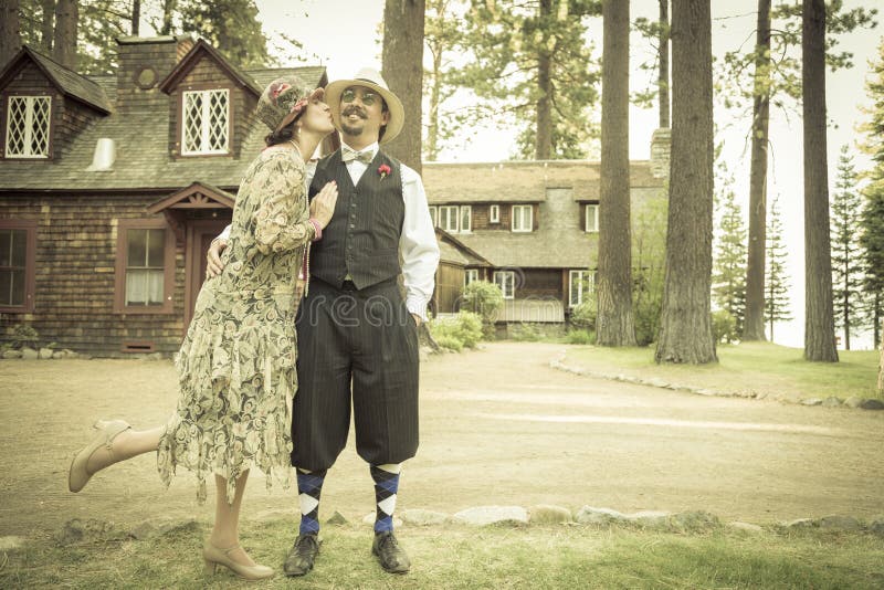 1920s Dressed Romantic Couple in Front of Old Cabin. Romance, house.