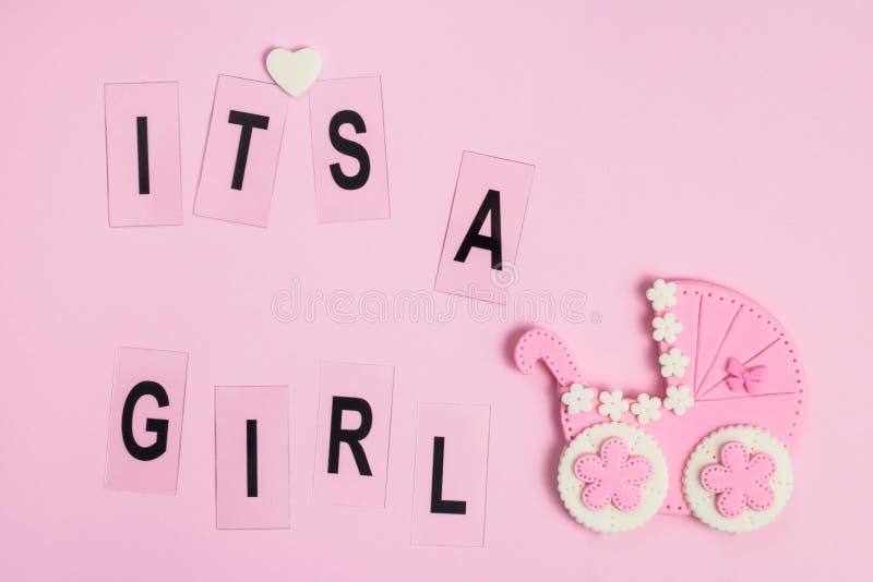 It`s a girl sign and little baby stroller on a pink card. Newborn background. Baby shower invitation. Baby announcement. Flat lay. It`s a girl sign and little baby stroller on a pink card. Newborn background. Baby shower invitation. Baby announcement. Flat lay