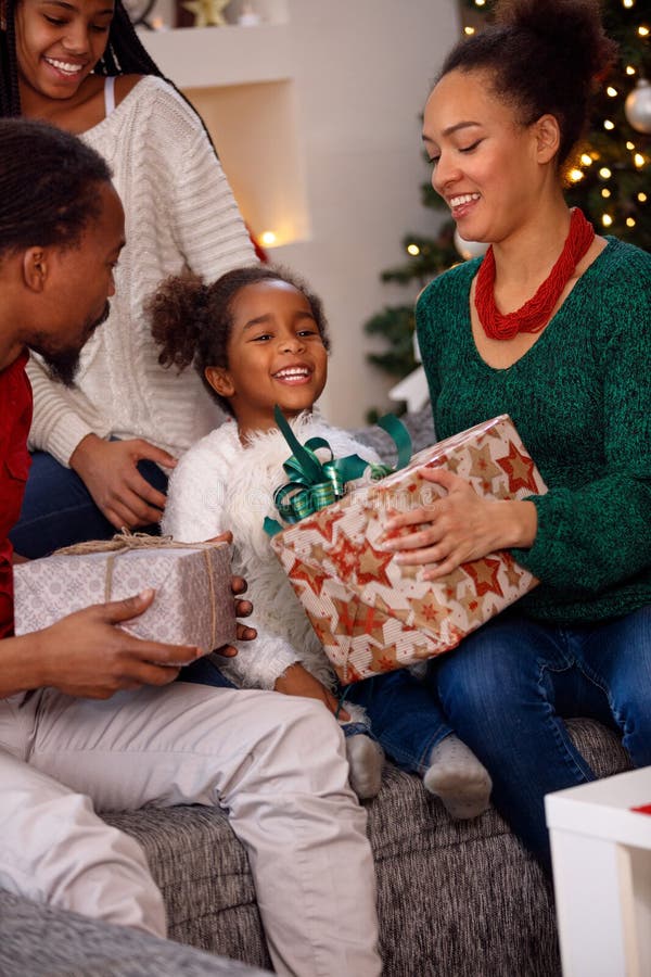 S'ouvrir afro-américain de famille actuel sur Noël photo libre de droits S'ouvrir afro-américain de famille actuel sur Noël photo libre de droits
