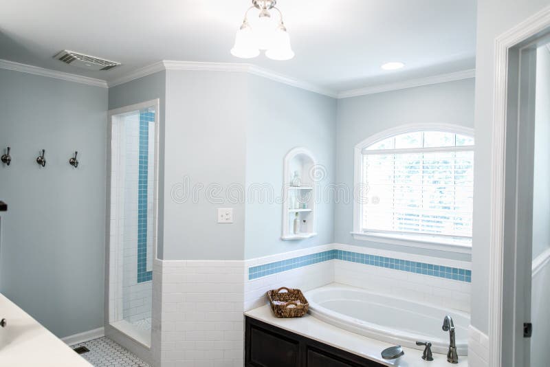 1950`s style bathroom with tile floor and dark brown cabinets in white and blue accents