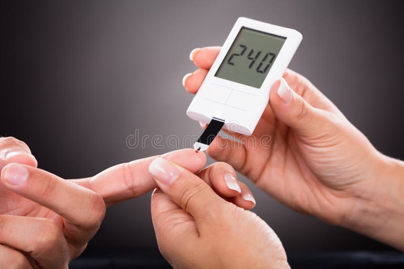 Close-up Of A Doctor Checking Patient`s Sugar Level With Glucometer. Close-up Of A Doctor Checking Patient`s Sugar Level With Glucometer