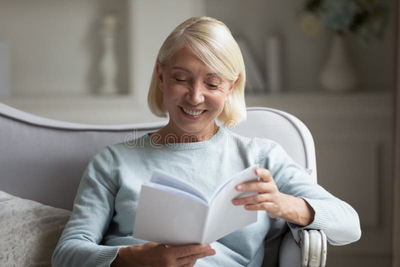 60s woman enjoy free time reading interesting book