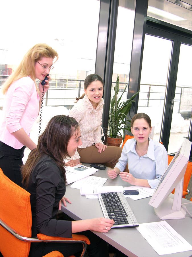 Atraktívne tím mladých žien v kancelárii, smeje sa a pozeral sa na obrazovke počítača.