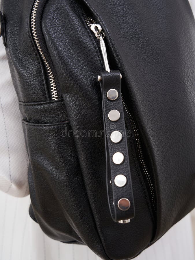 Sacchetto di cuoio nero snello con dettagli cerniere e stuoie metalliche su cinghia creando un accessorio elegante e moderno fotografia stock libera da diritti