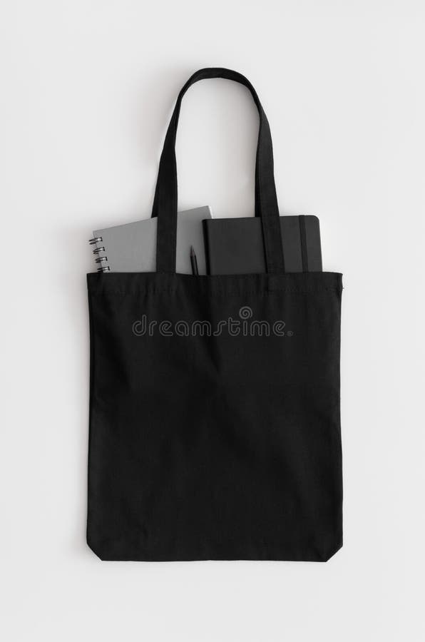 Sacchetto nero per sacchetti con quaderni su tavolo bianco immagine stock libera da diritti