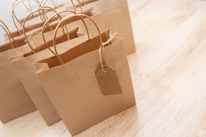 Sacchi di carta di Brown Kraft per i regali su fondo immagine stock libera da diritti Sacchi di carta di Brown Kraft per i regali su fondo immagine stock libera da diritti