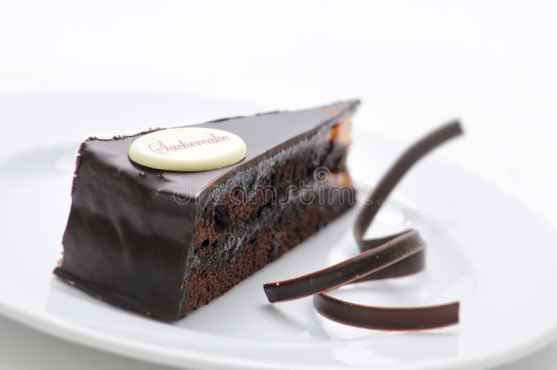 Sacher torte, chocolade scherp met wervelingen op witte plaat, zoet dessert, patisserie, fotografie voor winkel stock foto Sacher torte, chocolade scherp met wervelingen op witte plaat, zoet dessert, patisserie, fotografie voor winkel stock foto