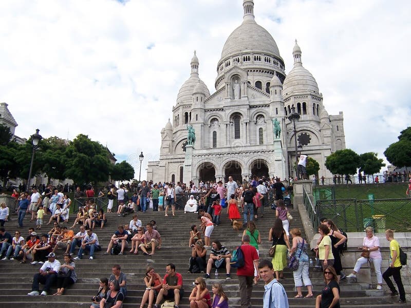 Sacre Coeur Basilica in summer day. A lot of tourists sitting on the stairs. Large medieval cathedral. August 05, 2009, Paris,. Sacre Coeur Basilica in summer royalty free stock image Sacre Coeur Basilica in summer day. A lot of tourists sitting on the stairs. Large medieval cathedral. August 05, 2009, Paris,. Sacre Coeur Basilica in summer royalty free stock image