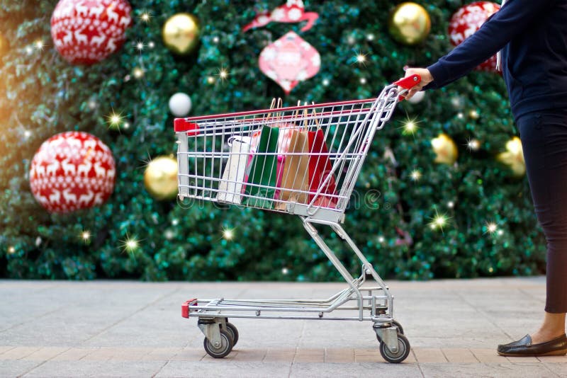 Sacs en papier achat-femelles de client de Noël dans le chariot images libres de droits Sacs en papier achat-femelles de client de Noël dans le chariot images libres de droits