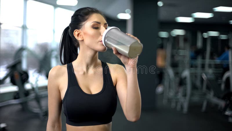 Sacudida de consumición de la proteína de la mujer deportiva después del entrenamiento, nutrición del aumento del músculo, salud fotografía de archivo
