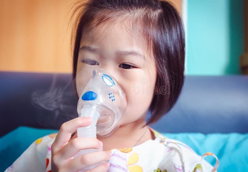 Sad asian child holds a mask vapor inhaler for treatment of asthma. Breathing through a steam nebulizer. royalty free stock photo Sad asian child holds a mask vapor inhaler for treatment of asthma. Breathing through a steam nebulizer. royalty free stock photo