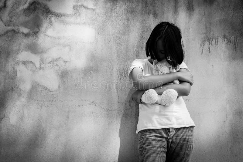 Sad asian girl alone with white bear near old wall cement