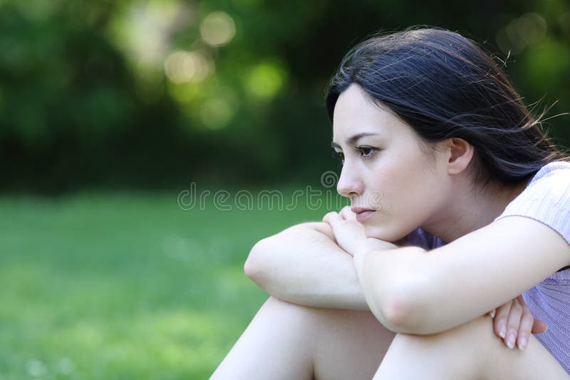 Sad asian woman complaining looking away in a park