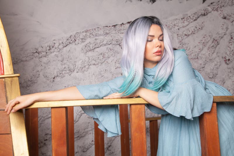 Sad Beautiful Woman In Blue Dress Posing In Studio With Wooden Ship