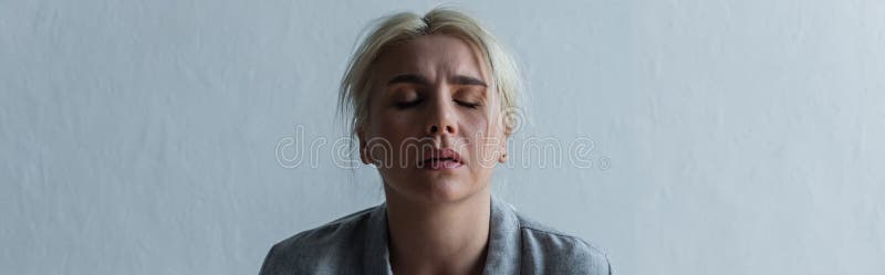 sad blonde woman with climax and closed eyes at home, banner,stock image