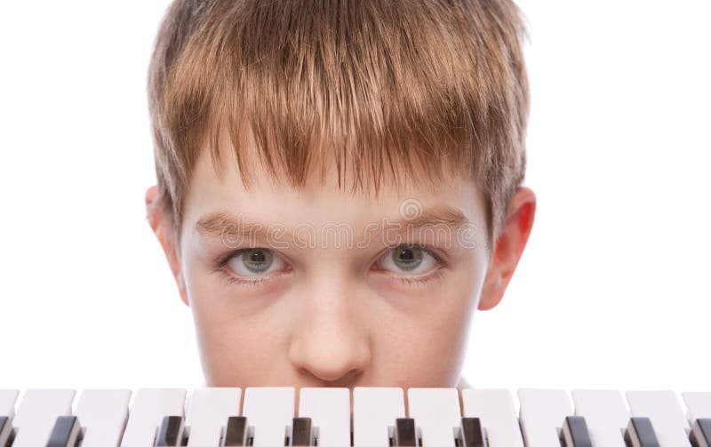 Sad boy near piano keyboard