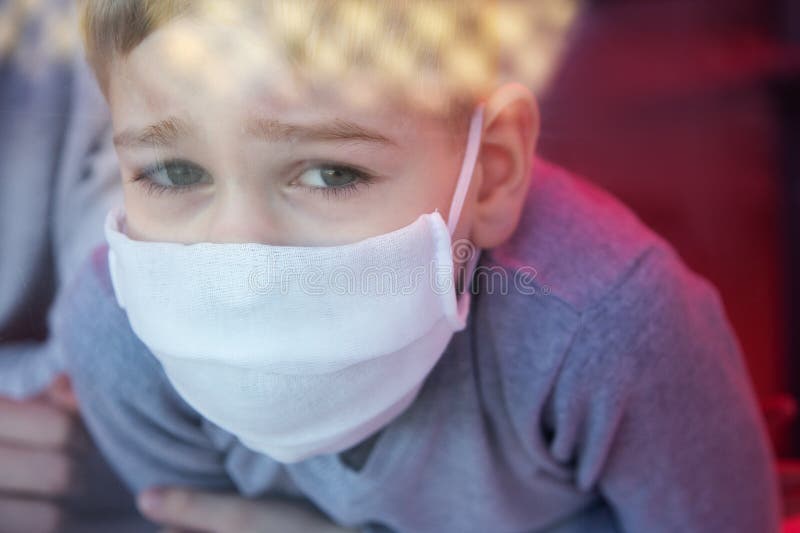 Sad Boy Wearing Protective Masks Loking through the Window Stock Image