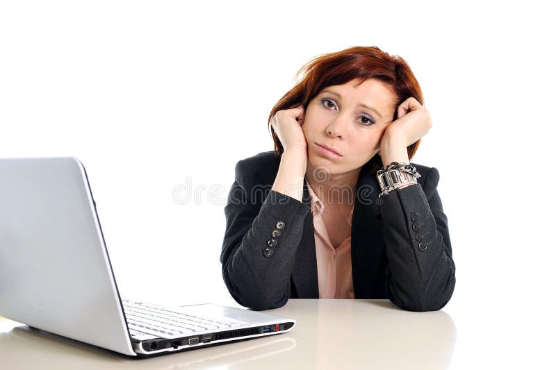 Triste business rosso donna dai capelli stress sul posto di lavoro con computer isolato su sfondo bianco.