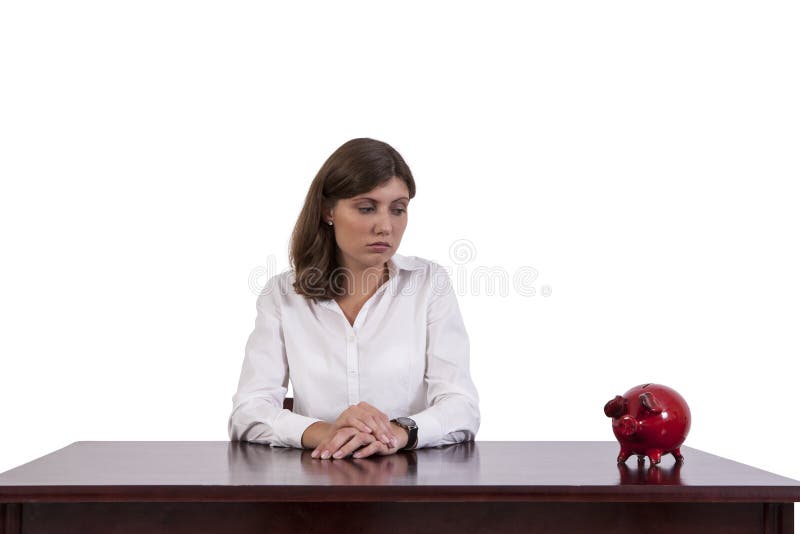 Sad businesswoman looking at piggy bank