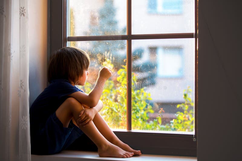 Sad child, boy, sitting on a window shield