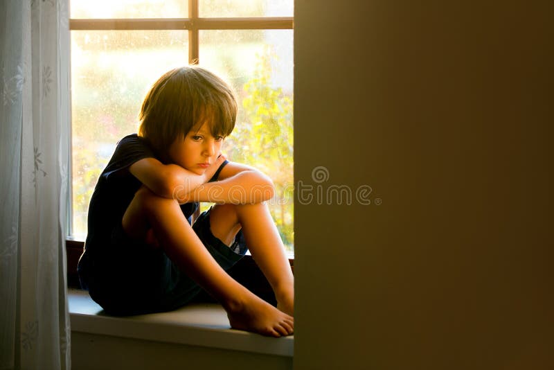 Sad child, boy, sitting on a window shield