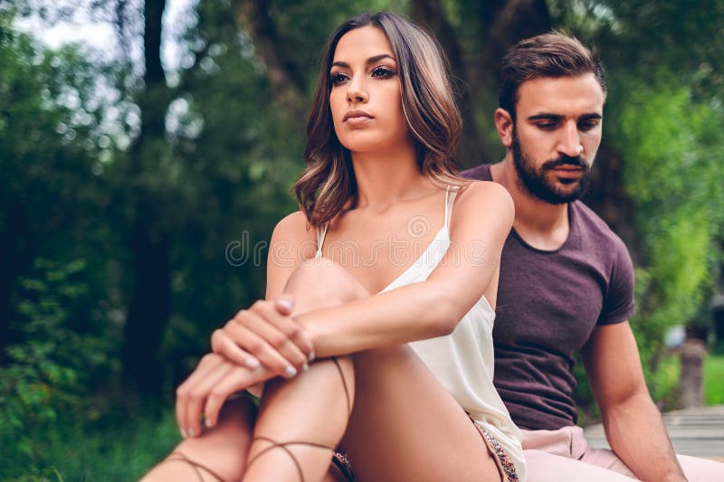 Sad couple sitting in the park stock photo Sad couple sitting in the park stock photo