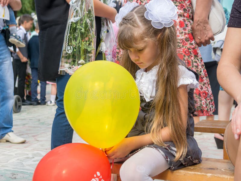 Sad girl sitting with balls in hands, on September 1 holiday