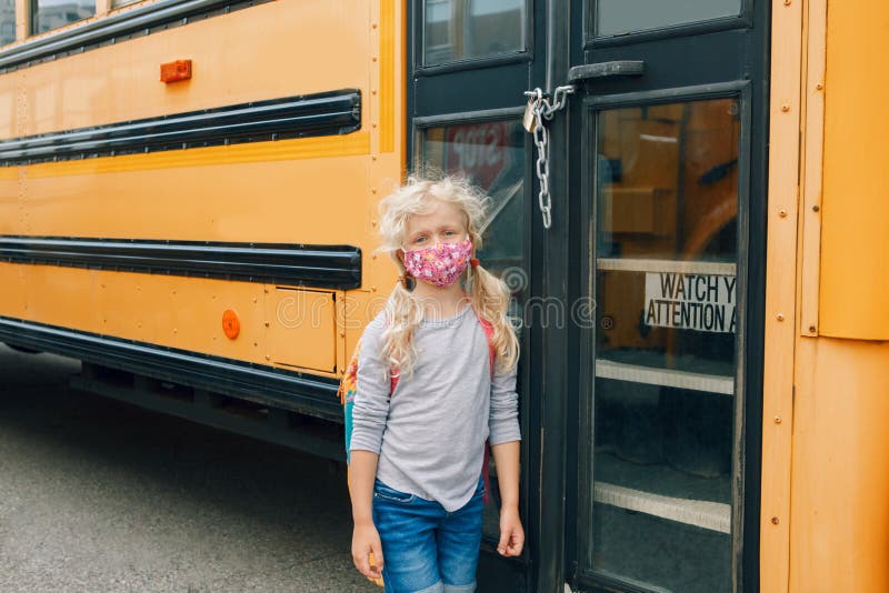 Sad girl student with face mask near locked yellow bus. Closed school during pandemic lockdown and quarantine shutdown. Education royalty free stock photography Sad girl student with face mask near locked yellow bus. Closed school during pandemic lockdown and quarantine shutdown. Education royalty free stock photography
