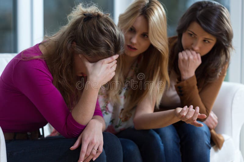 Sad girl and supporting friends stock images