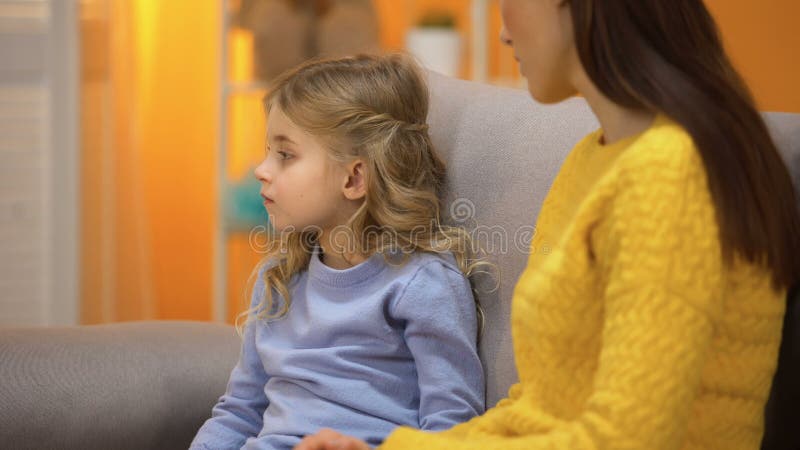 Sad girl turning away from lady, not accepting babysitter, conflict with mother