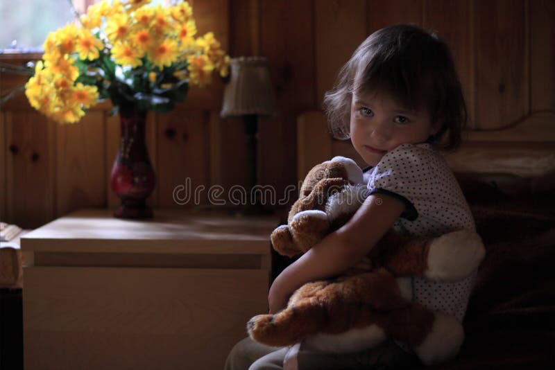 Sad little girl hugging teddy bear