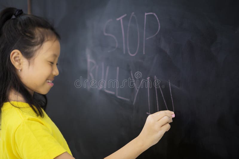 Sad little girl writing a text of stop bullying royalty free stock photography Sad little girl writing a text of stop bullying royalty free stock photography