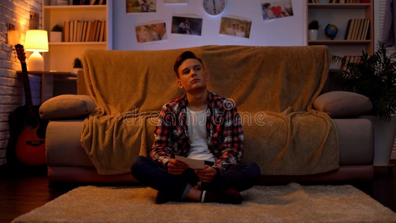 Sad lonely student looking at girlfriends photo, suffering breakup, relations royalty free stock images Sad lonely student looking at girlfriends photo, suffering breakup, relations royalty free stock images