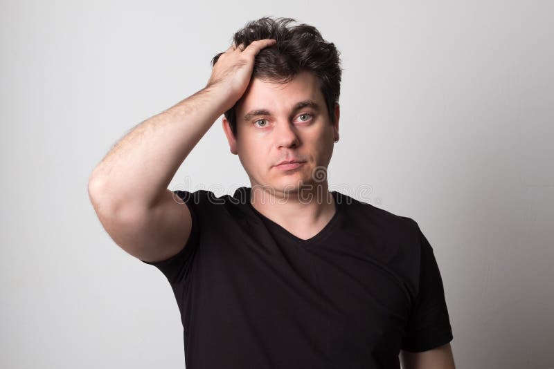 Sad man in a black t-shirt. Young man with beautiful hair.