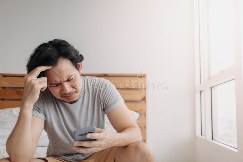 Sad man has bad online chat news and feels disappointed on the smartphone.  Stock Photo by ©sevendeman 506404148